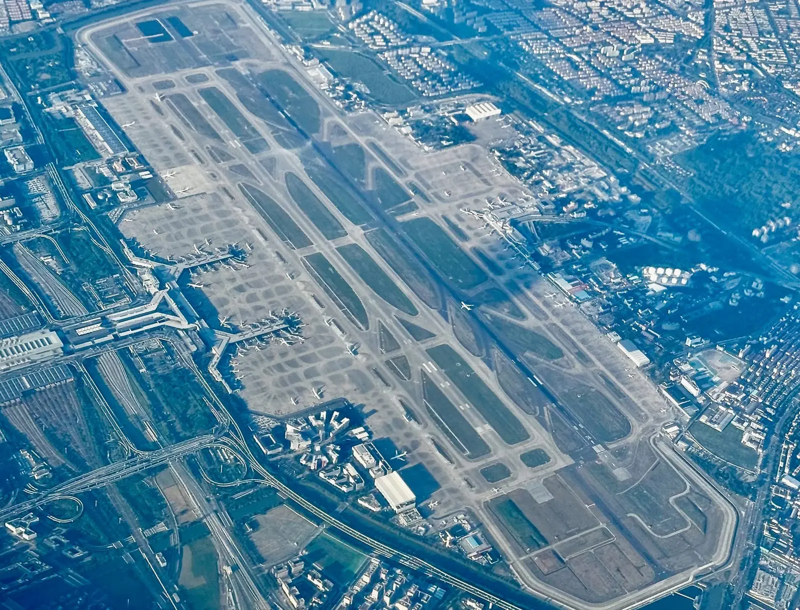 大型機場跑道與航廈空拍,上海轉機需預留交通與航廈動線時間
