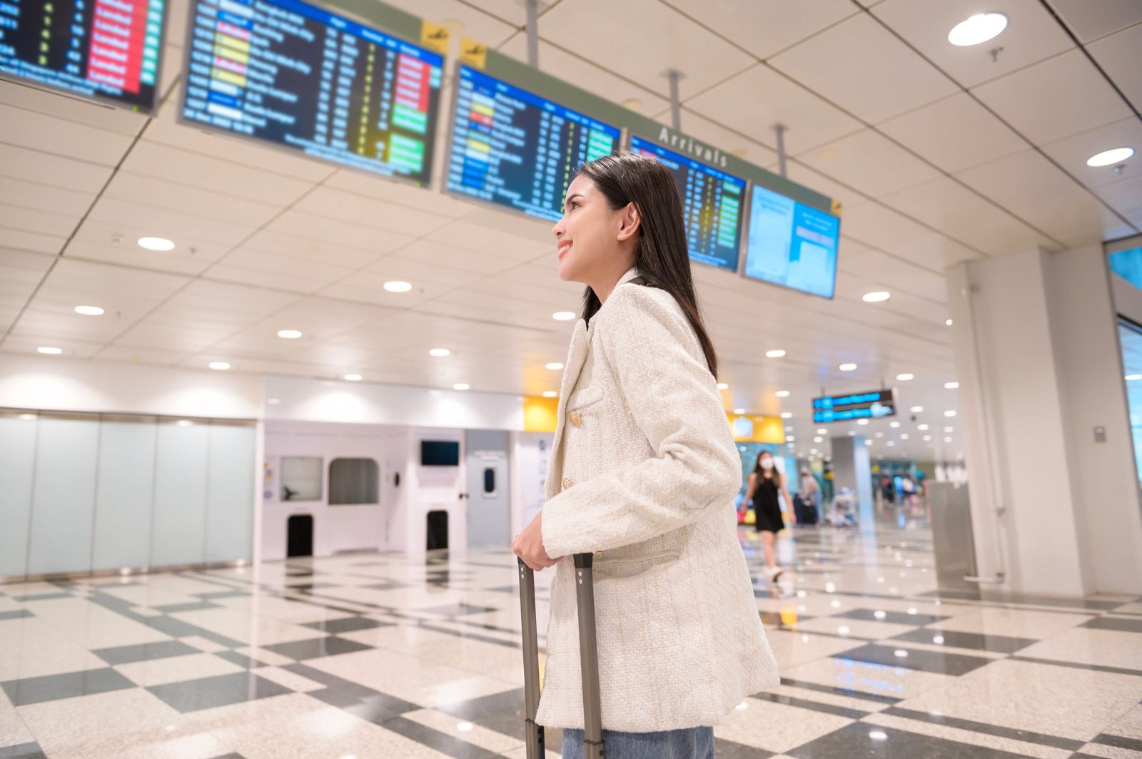 旅客在機場航班資訊看板前準備搭機