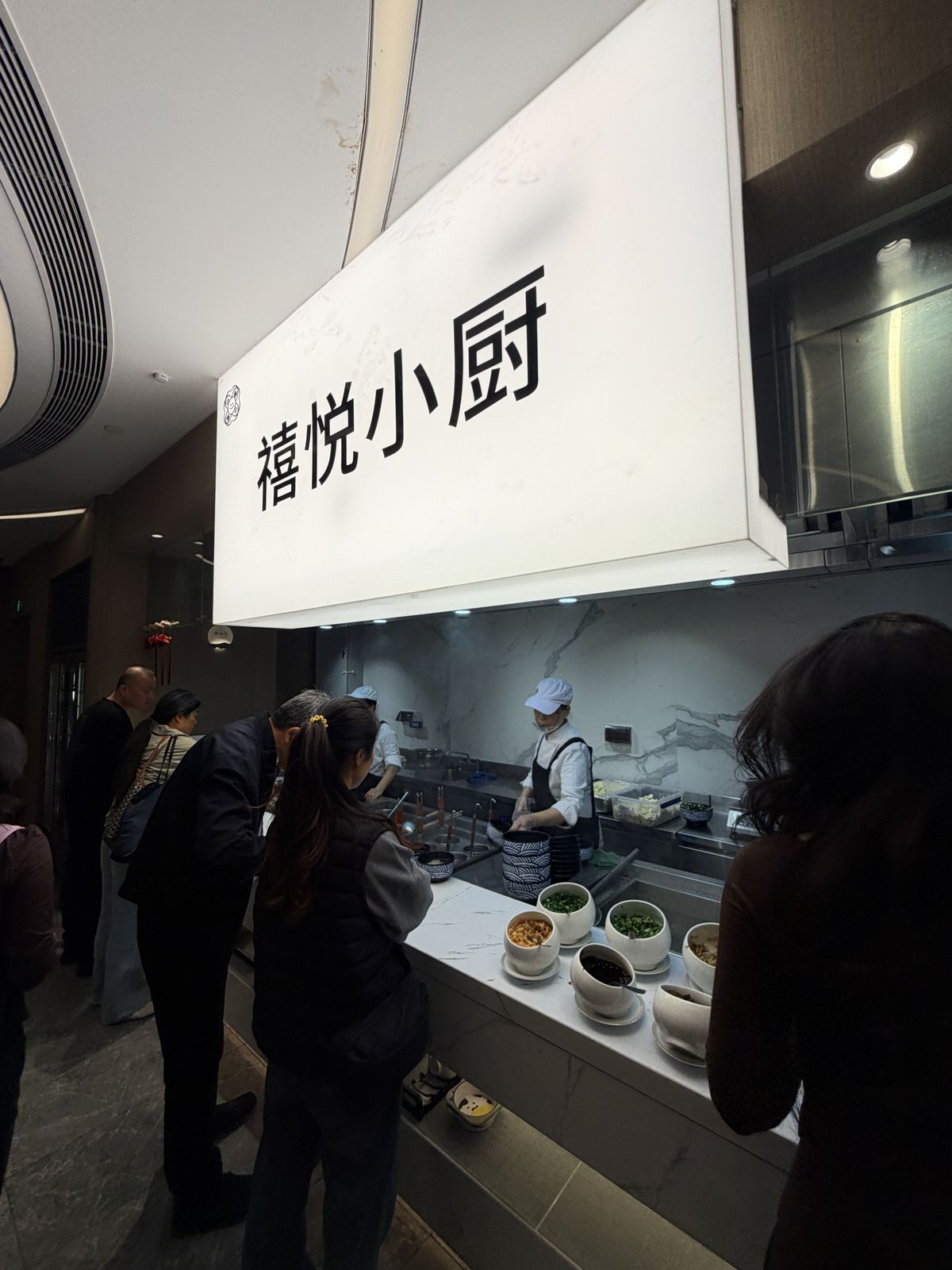 禧悅小廚現煮區招牌與候餐旅客