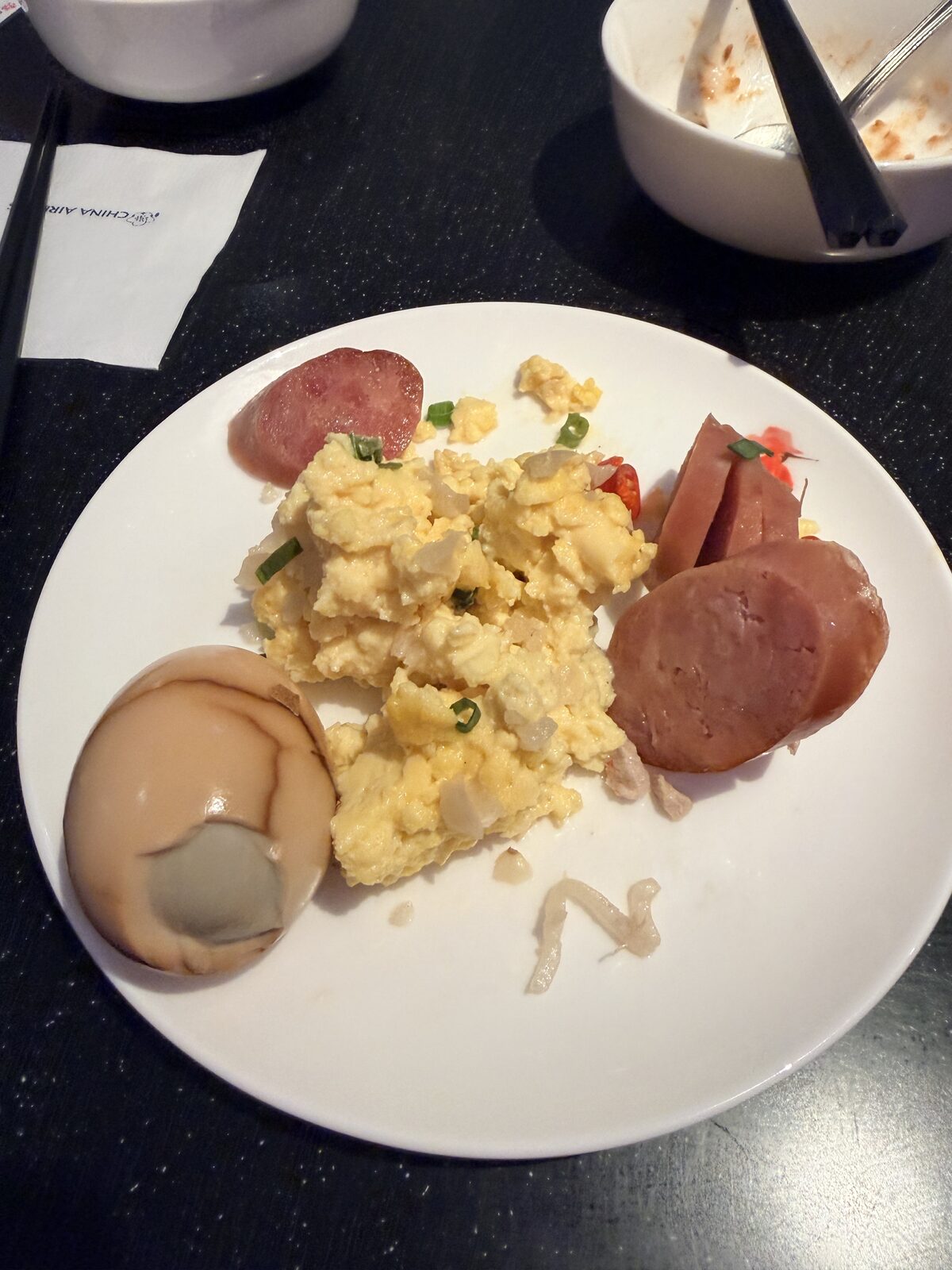 華航 D4 貴賓室早餐盤中的炒蛋火腿香腸與茶葉蛋