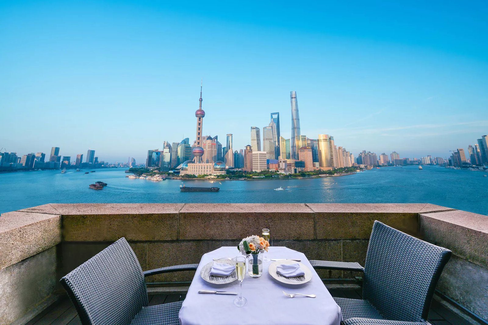 上海和平飯店露台雙人餐桌，隔著黃浦江正對東方明珠與陸家嘴高樓群