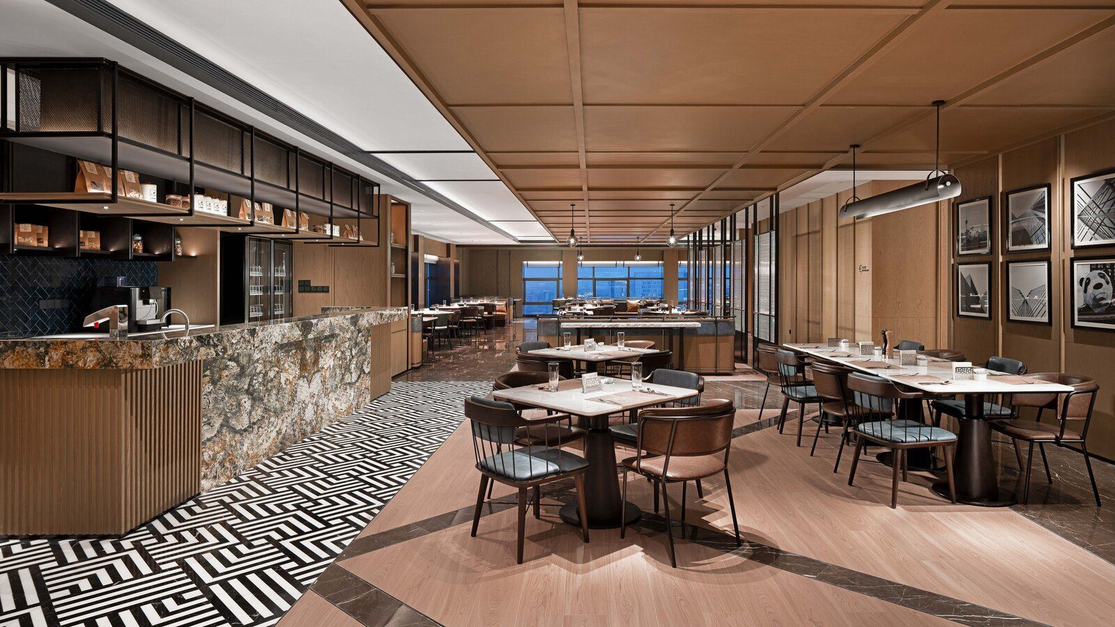 成都春熙路福朋喜來登酒店的 The MESH 玩啤食社，大理石檯面的餐檯旁排著方桌與皮革椅，遠處整排窗外是城市景