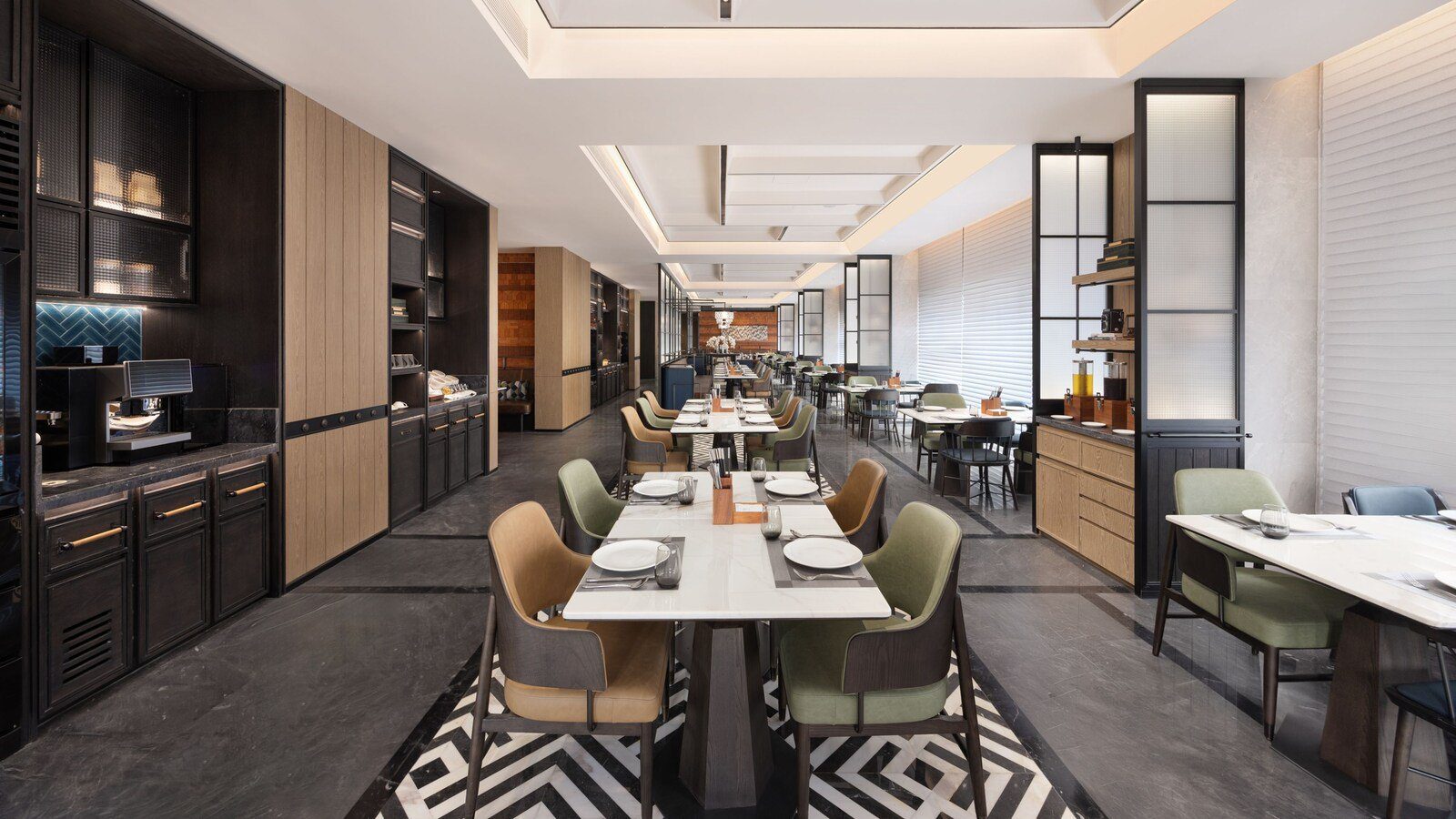 重慶渝中半島福朋喜來登酒店的 The Mesh 玩啤食社，黑白幾何地坪上排著長桌與綠色、焦糖色餐椅，左側是深色餐櫃與咖啡機