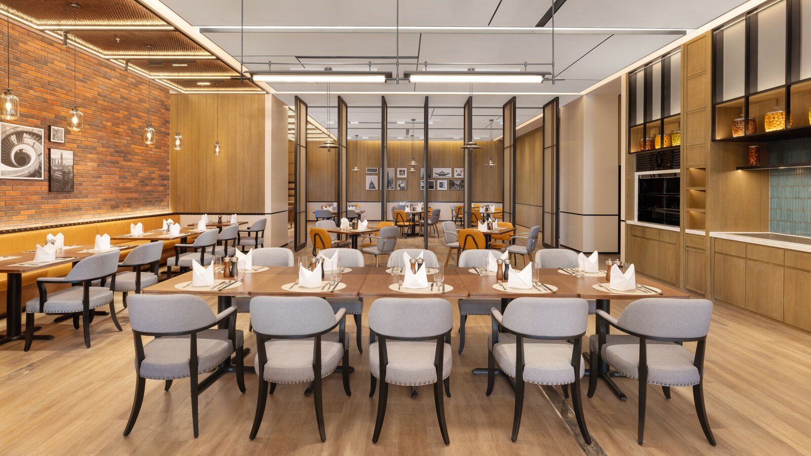 濟南高新區福朋喜來登酒店 THE MESH Cafe 全日餐廳，長桌擺著餐具，左側是紅磚牆與卡座