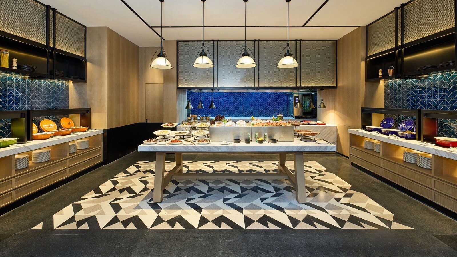 青島北岸瑞明福朋喜來登酒店 THE MESH 全日餐廳的自助區，中央長桌擺滿菜餚，兩側是藍色磁磚與餐檯