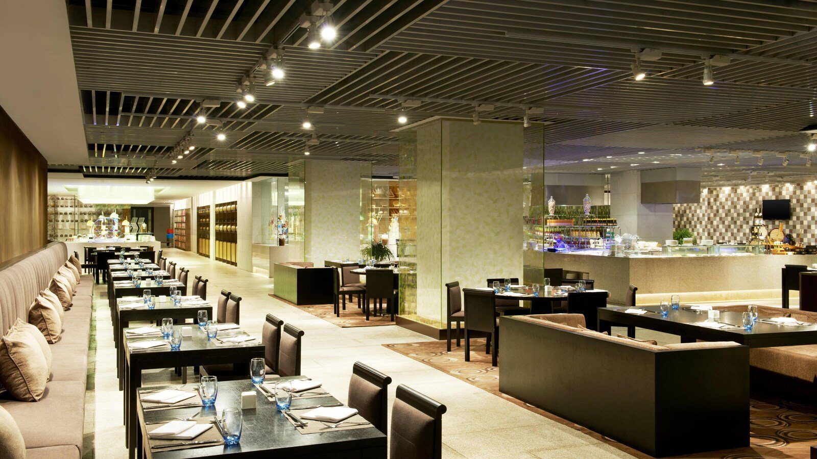 青島西海岸隆和福朋喜來登酒店 The Eatery 全日餐廳，長排卡座與深色餐桌延伸到後方的自助餐檯