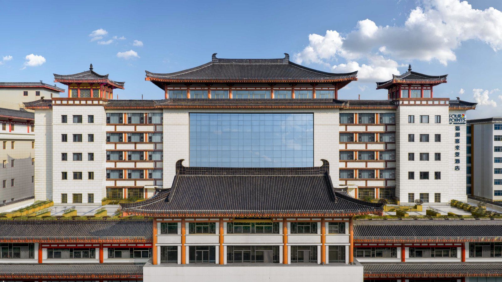 西安鐘樓福朋喜來登酒店白天的正面外觀,中式大屋頂與兩側塔樓,中間是玻璃帷幕