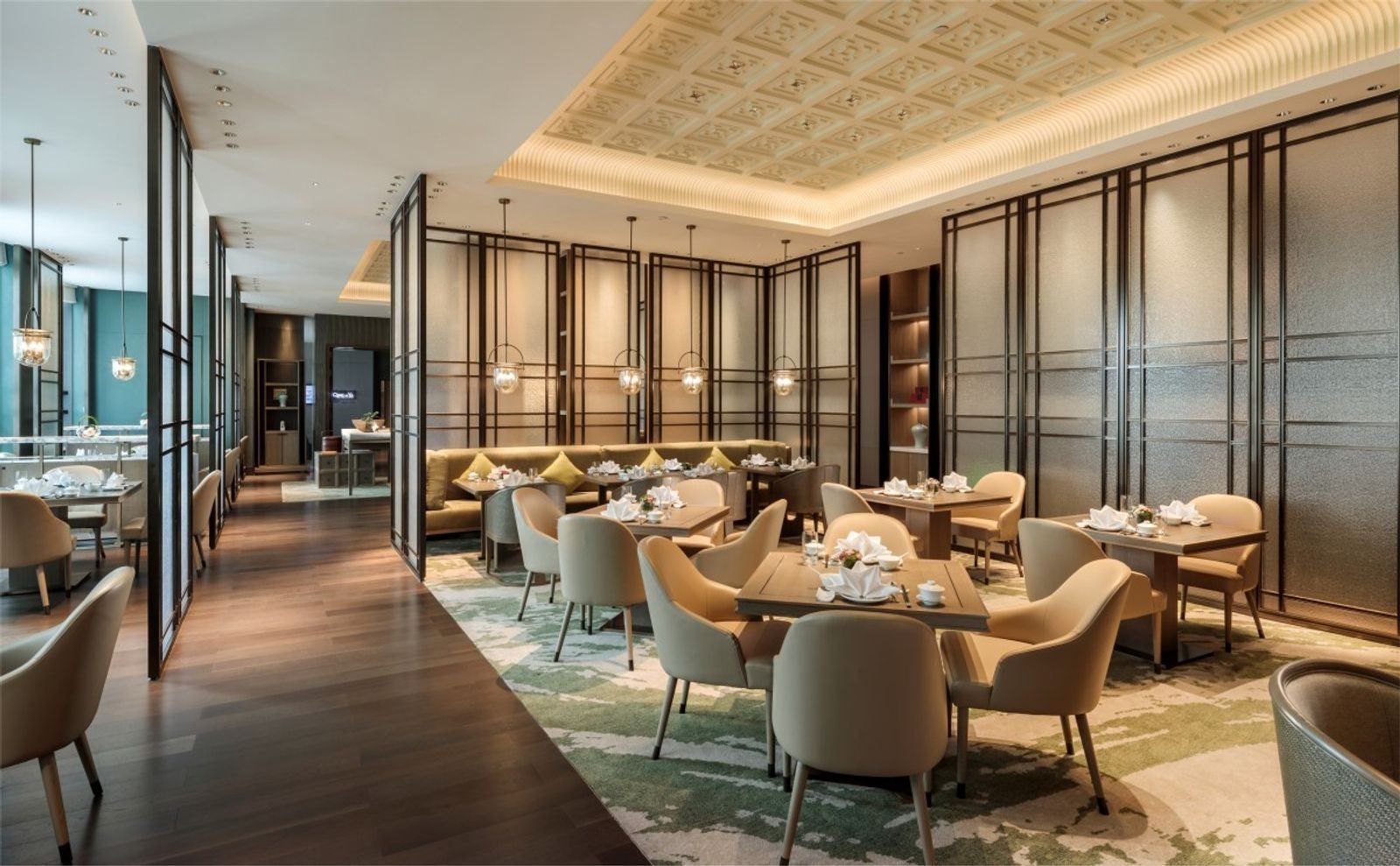 成都協信中心希爾頓酒店青雅中餐廳，深色格柵屏風隔出用餐區，方桌配米色扶手椅，天花板是方格浮雕