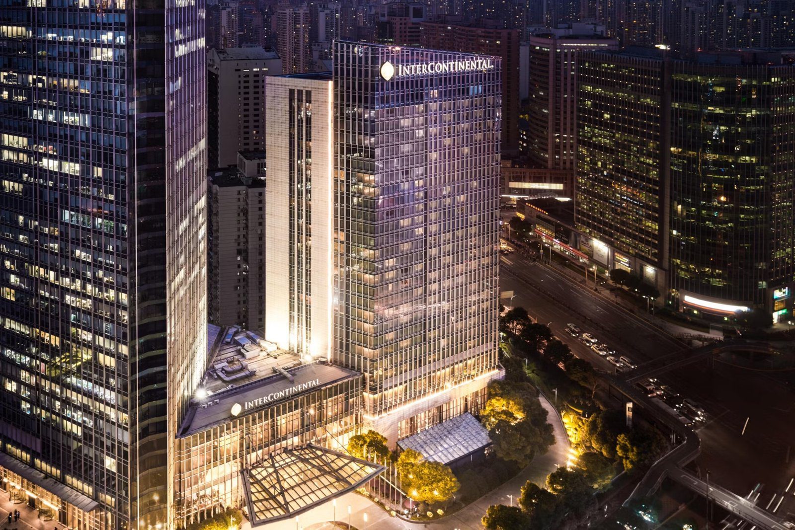 上海靜安洲際酒店夜間空拍，玻璃帷幕雙塔與周邊靜安一帶天際線