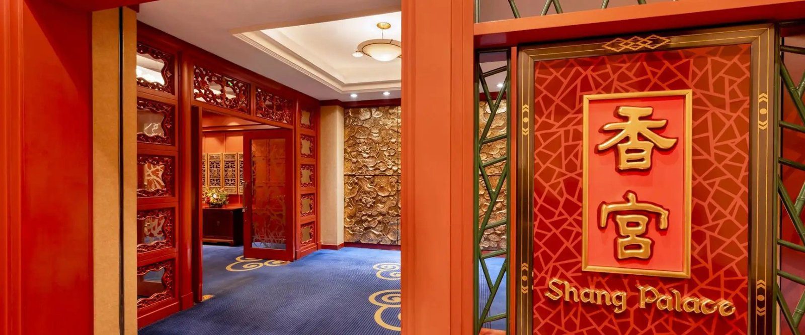 紅色木格門寫著香宮與 Shang Palace，門內是雕花木牆與藍色地毯