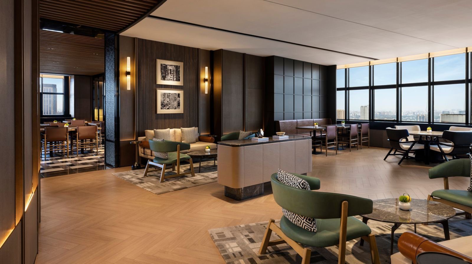 成都天府麗都喜來登飯店 35 樓 Sheraton Club 行政酒廊：綠色皮革單椅與大理石圓几、深色木牆與黑白掛畫，右側整排窗戶