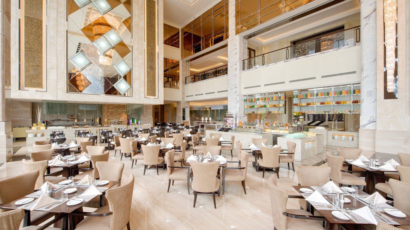 青島膠州綠城喜來登酒店盛宴全日餐廳，挑高空間裡排滿餐桌，後方是自助檯與果汁架