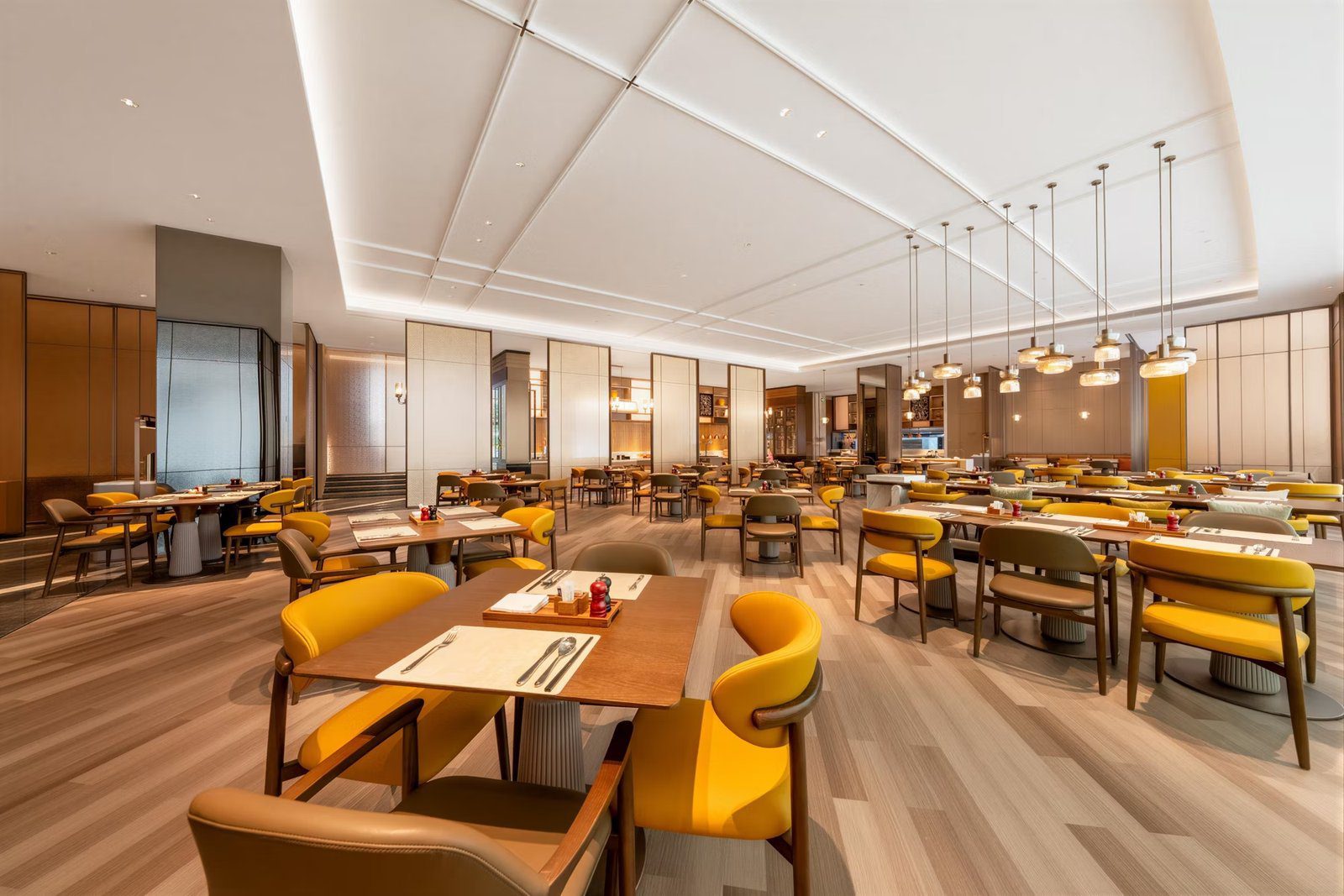 北京江西大廈天壇 voco 酒店餐廳的黃色座椅與挑高用餐區
