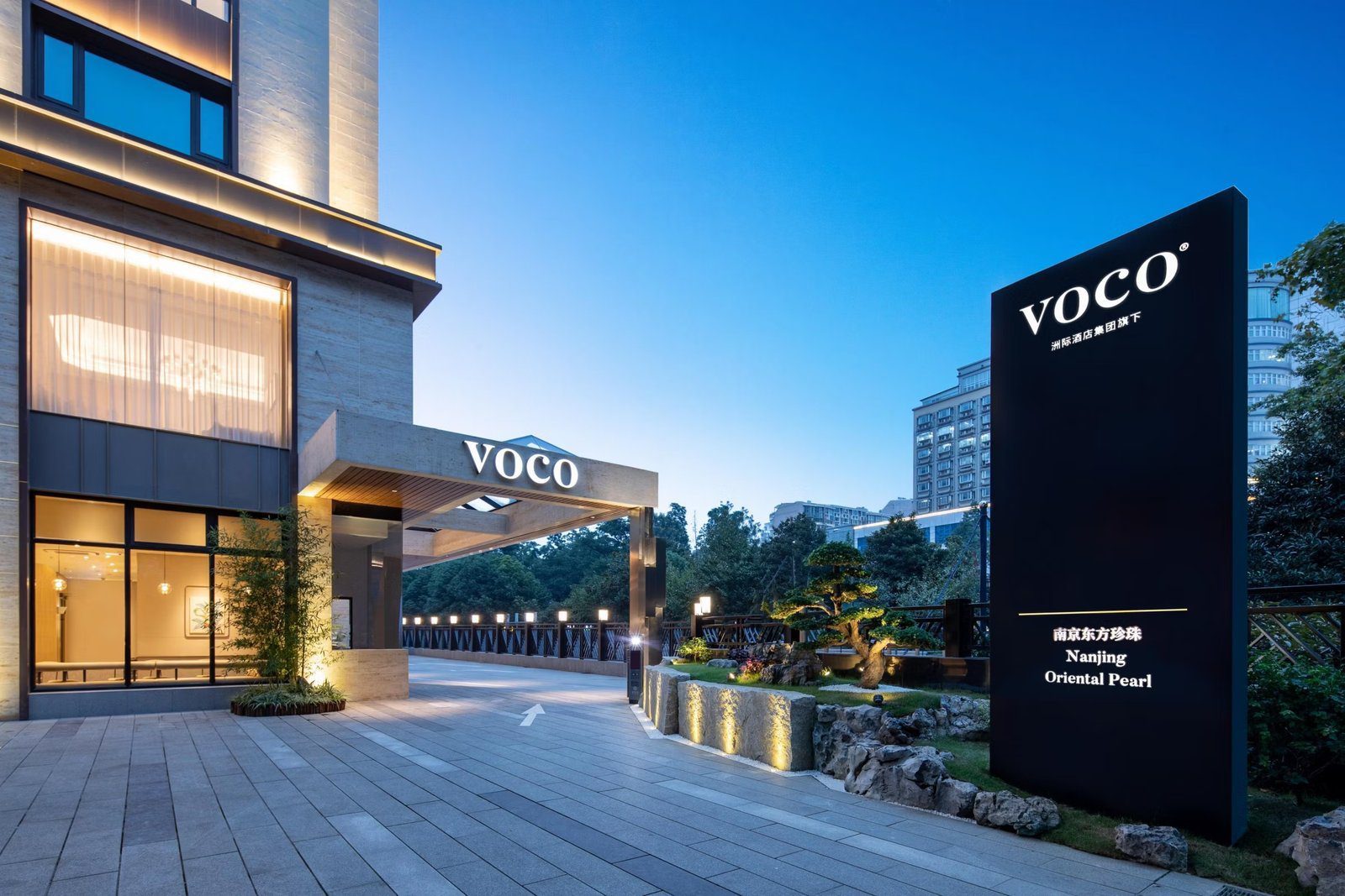 南京東方珍珠voco酒店入口，雨遮上是 VOCO 字樣，右側立著寫有 Nanjing Oriental Pearl 的黑色招牌與造型松