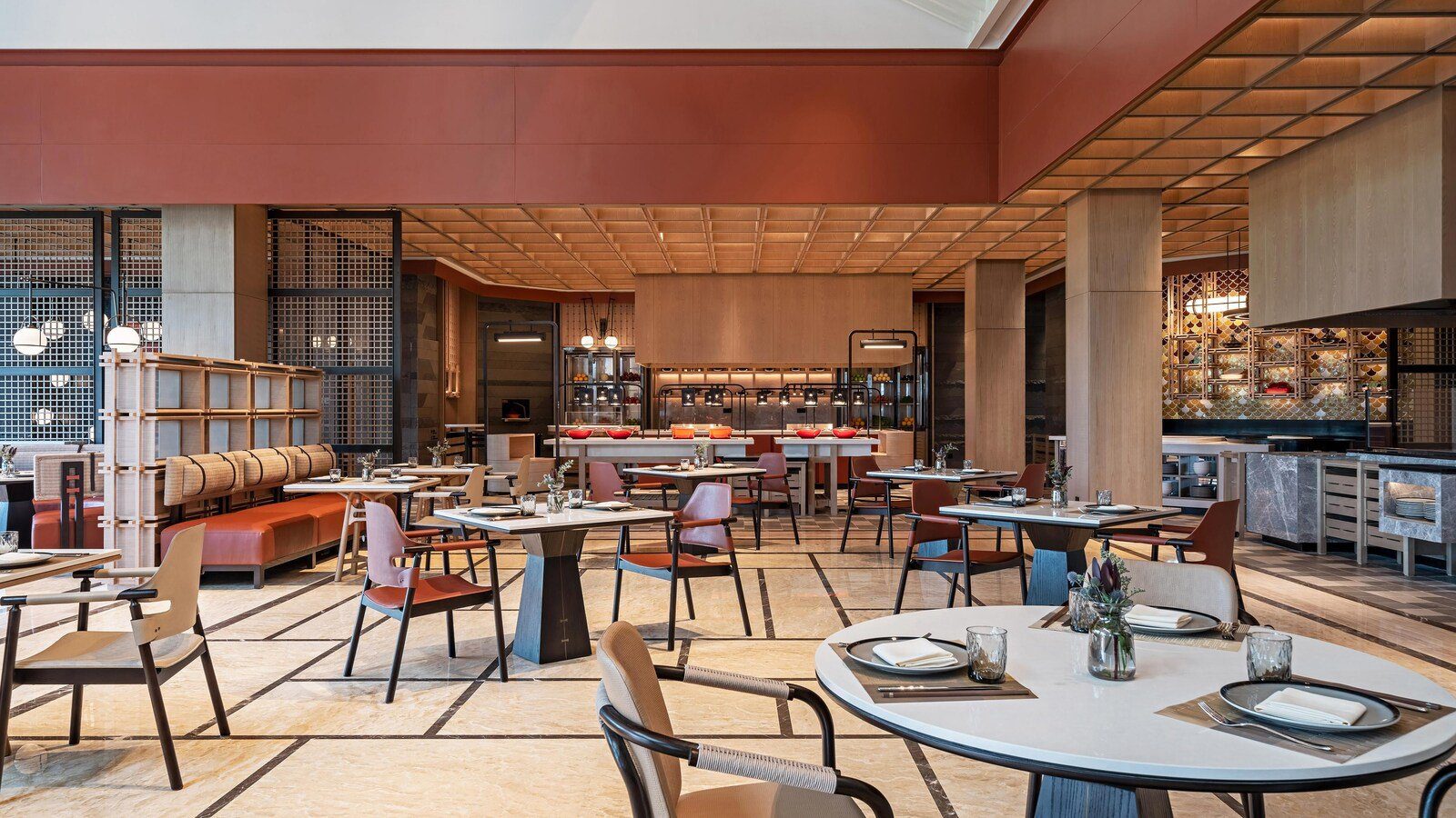 南京威斯汀溫泉度假酒店 The Market 的用餐區，格子天花板下擺著木桌與橘色皮椅，後方是自助餐檯
