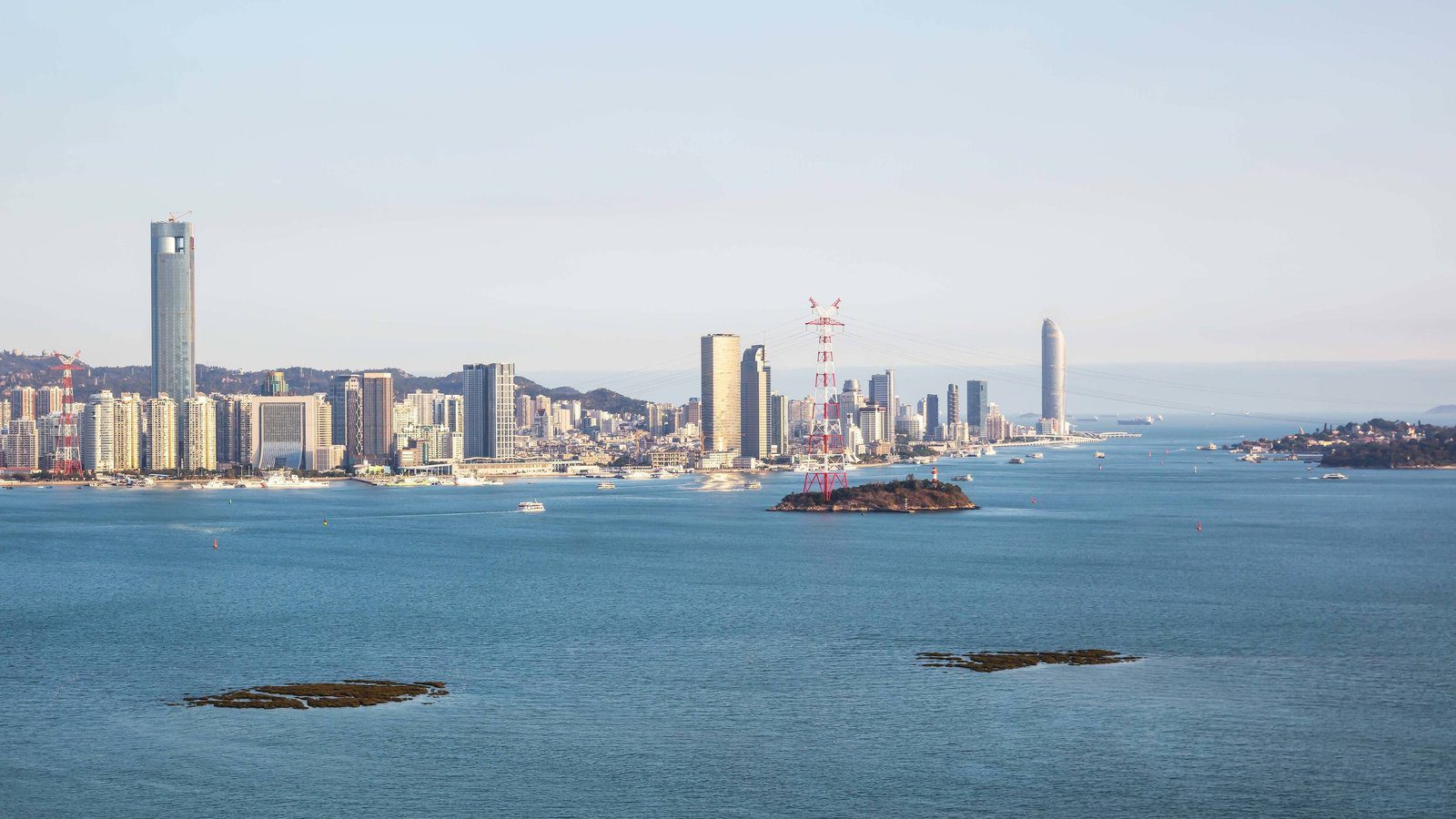 從海滄望向海灣對岸的廈門島天際線，海面上有幾座小島（周邊景觀）