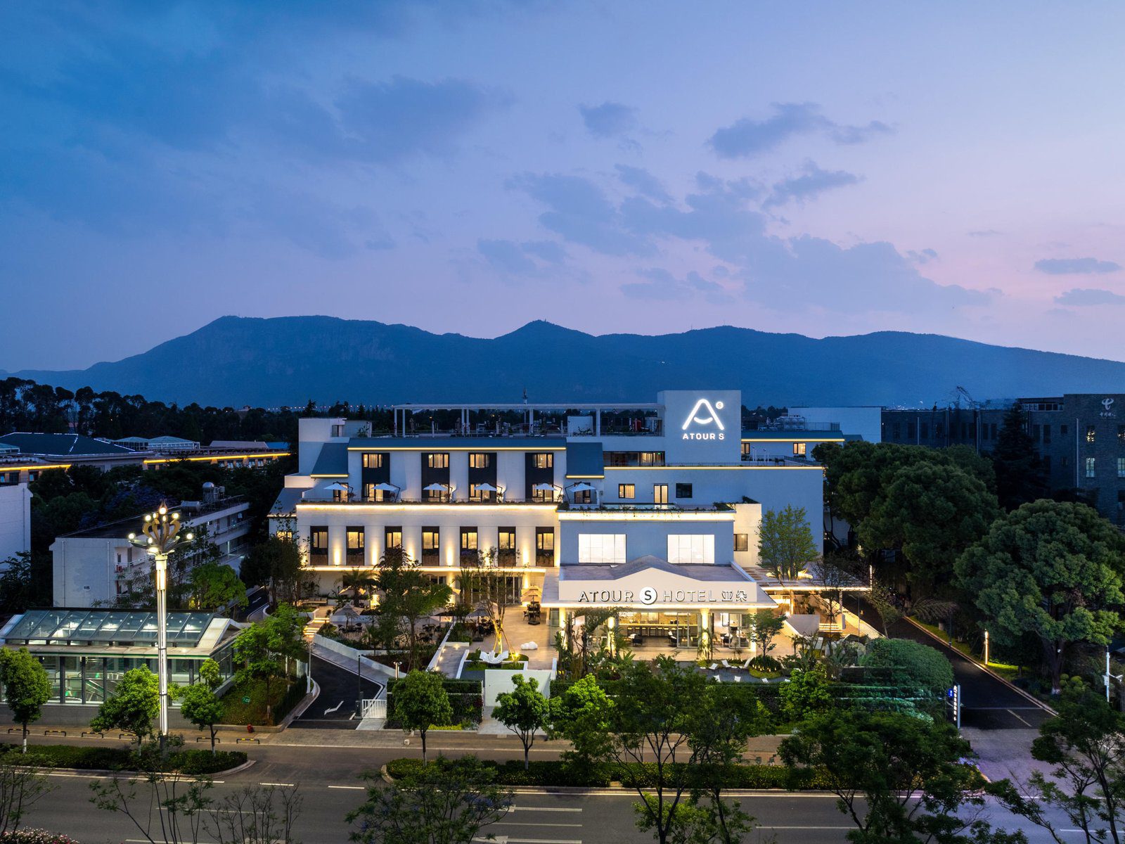 昆明滇池度假區滇池路亞朵S酒店黃昏時的建築外觀與遠方山景