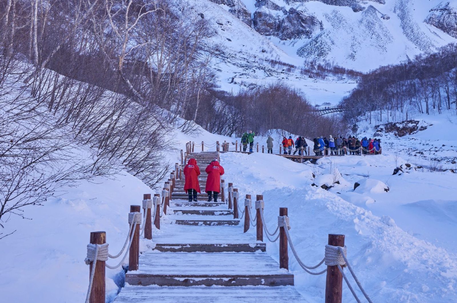 長白山冬季雪地木棧道,遊客沿步道走向雪白山谷
