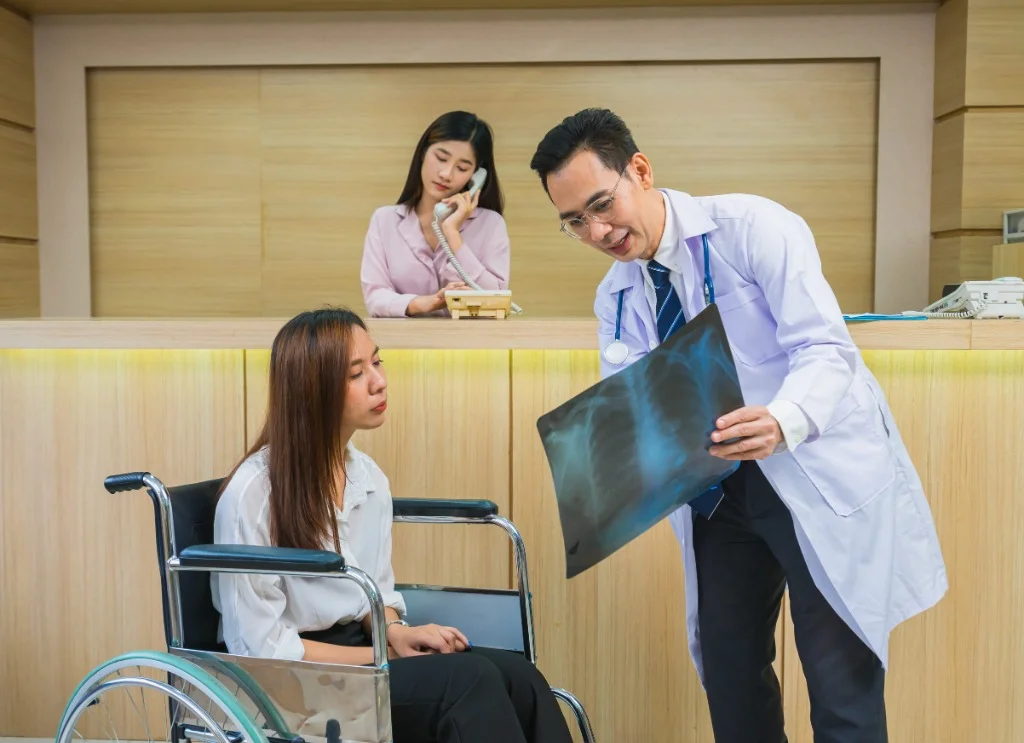 醫師於診間為坐輪椅的患者檢視說明胸部X光醫療影像