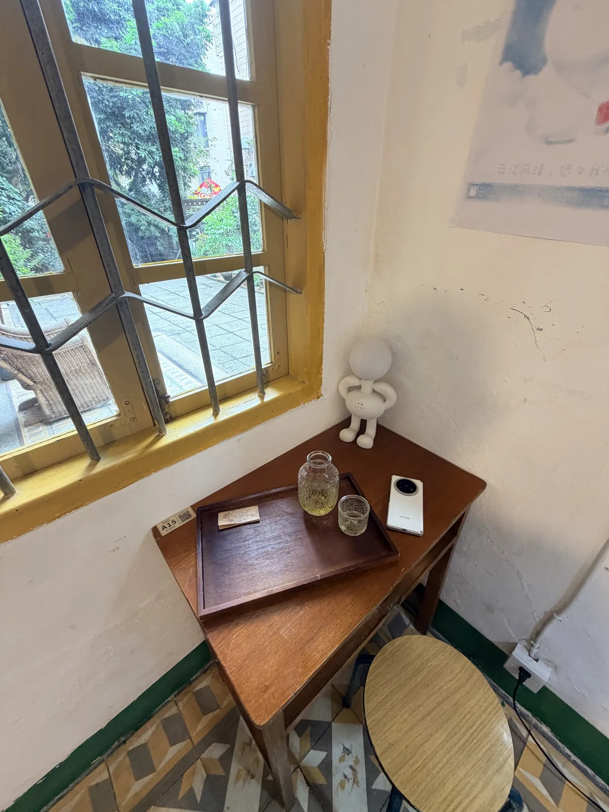 集岑路7號老宅靠窗小桌上的茶飲與黃木框窗
