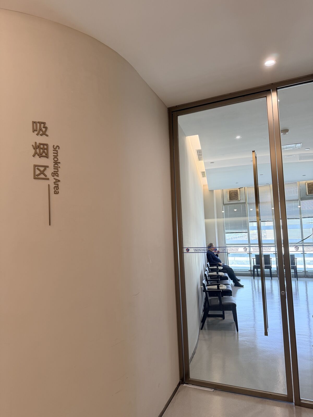 候機室內標示吸菸區的玻璃隔間入口