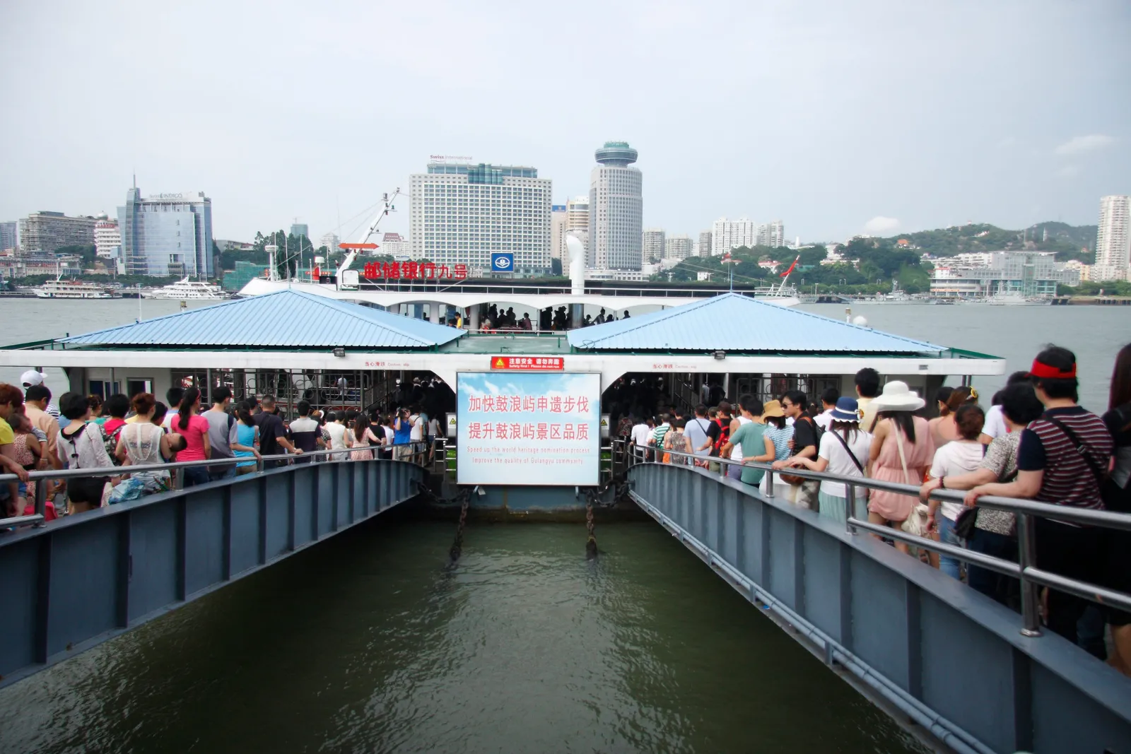 鼓浪嶼碼頭棧橋上排隊上船的旅客,對岸是廈門市區高樓