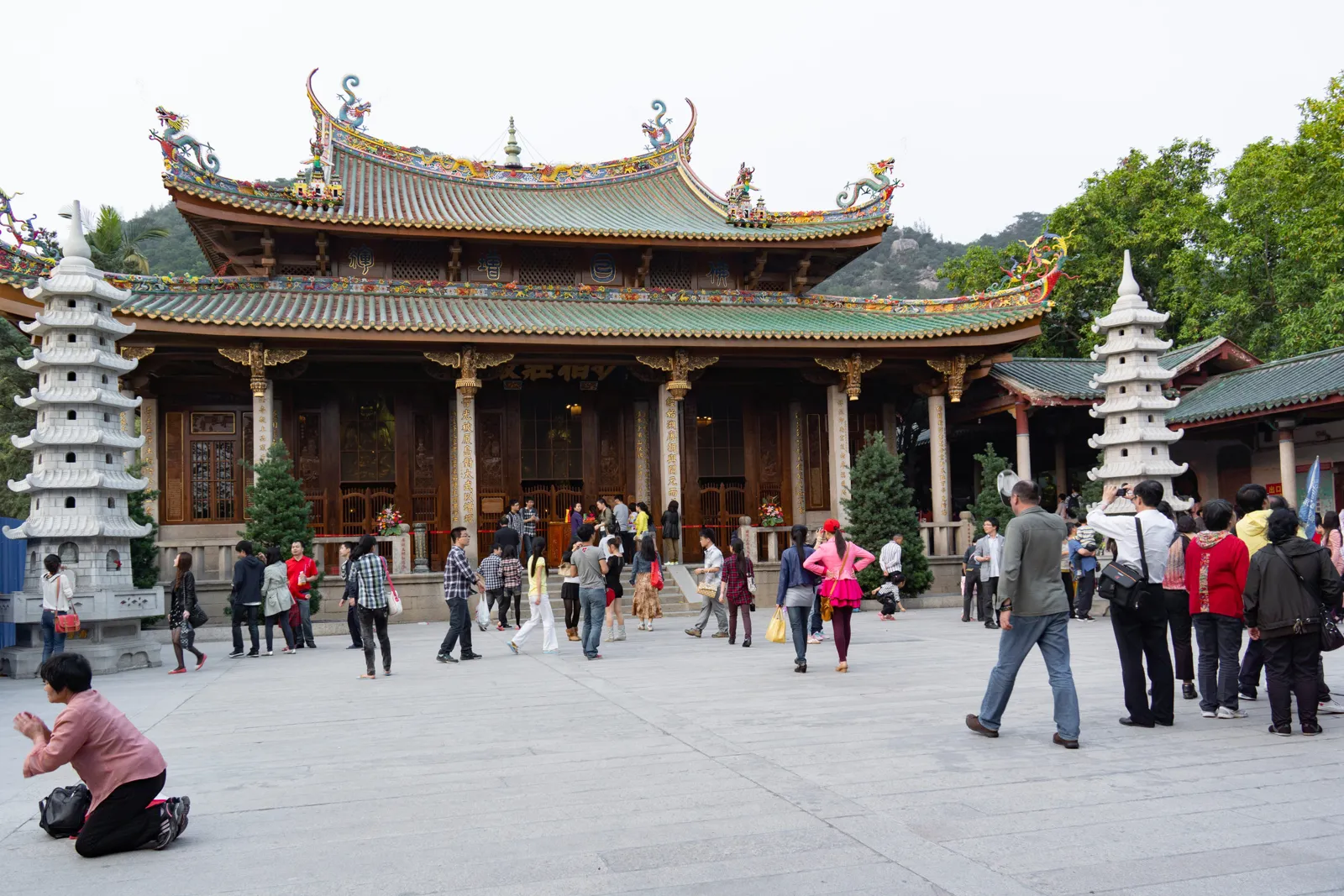 南普陀寺殿前廣場的白色石塔、燕尾屋脊殿宇與參拜信眾