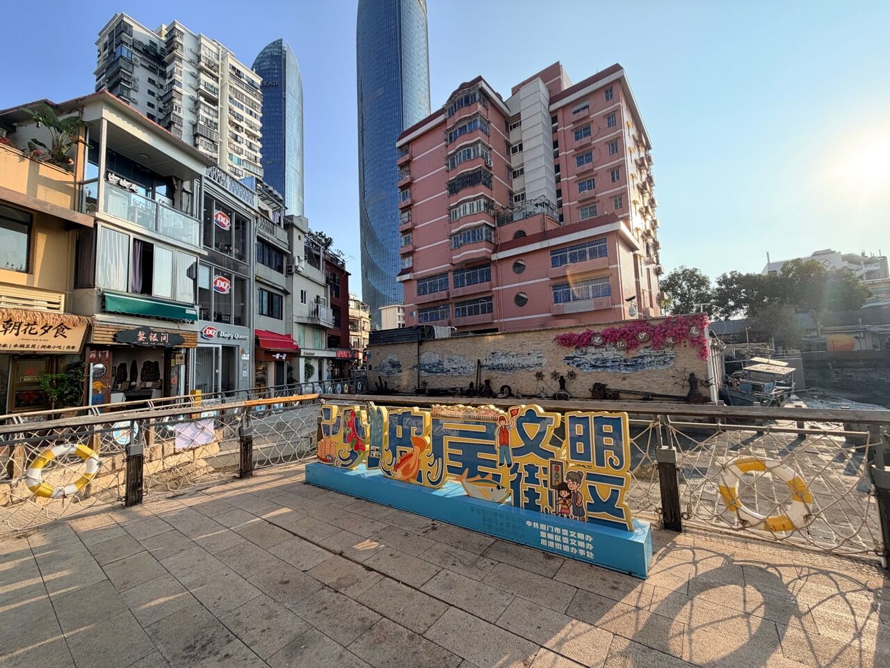 避風塢岸邊的沙坡尾文明街區裝置，後方是街屋與雙子塔