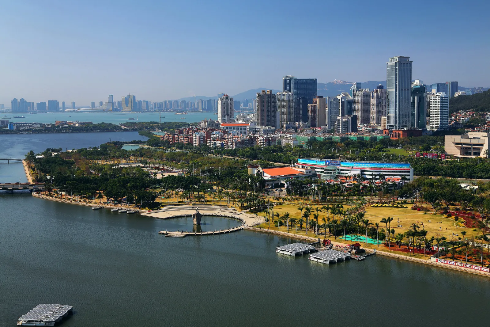 從高處俯瞰濱水公園綠地與步道,後方是城市高樓天際線